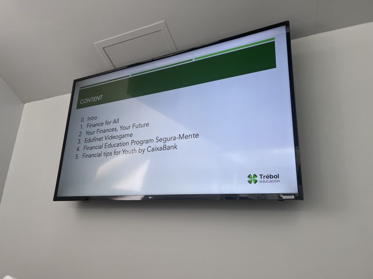Monitor ścienny wyświetlający slajd z agendą szkolenia pt. „CONTENT” oraz logiem Trébol educación.